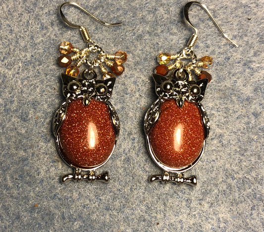 Large silver and orange goldstone gemstone owl charm earrings adorned with small dangling orange and amber Czech glass beads.