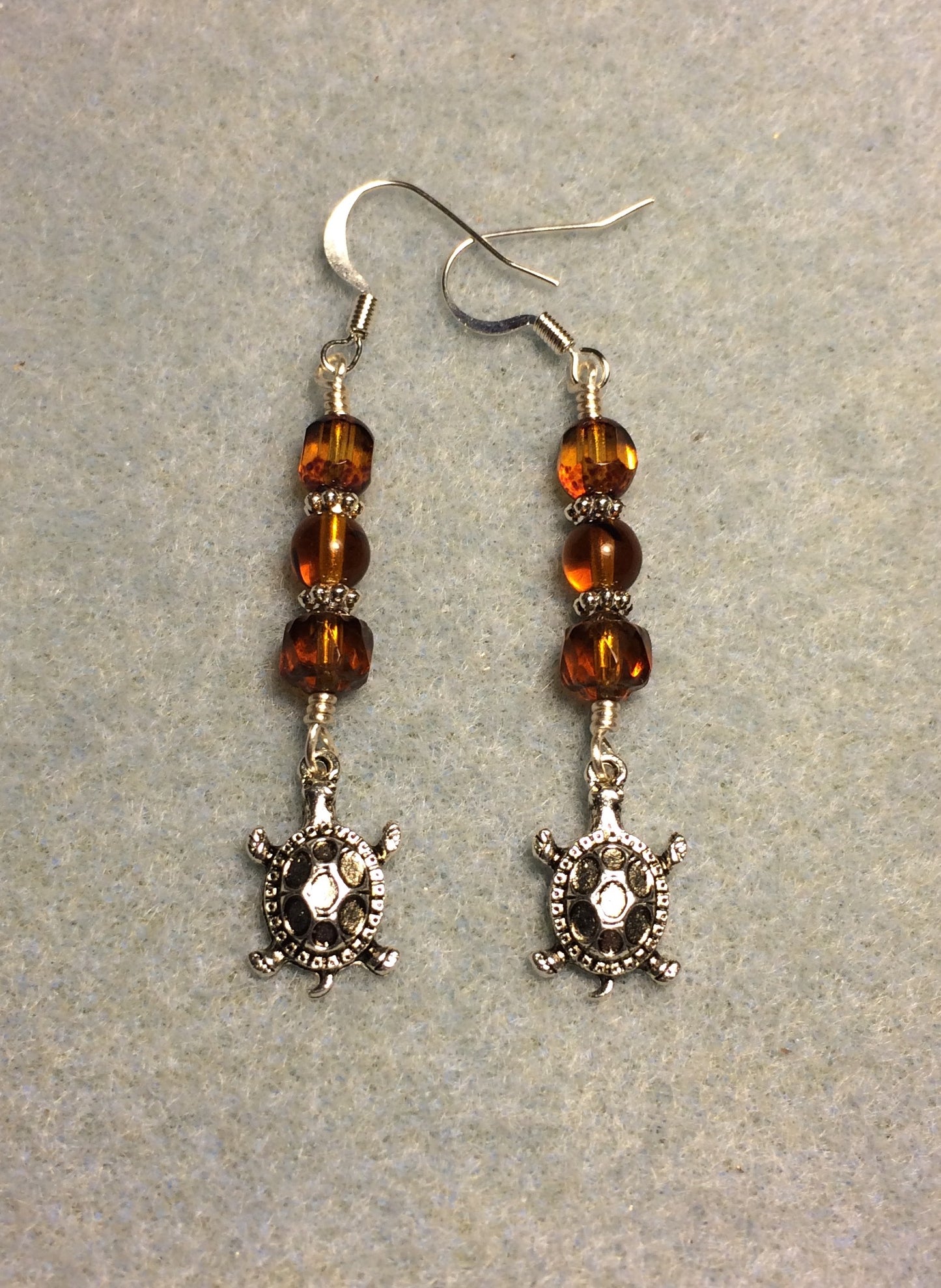 Silver tortoise charm earrings adorned with topaz Czech glass beads