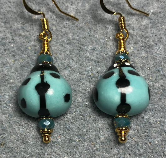 Light teal and black ceramic ladybug bead earrings adorned with teal Chinese crystal beads.