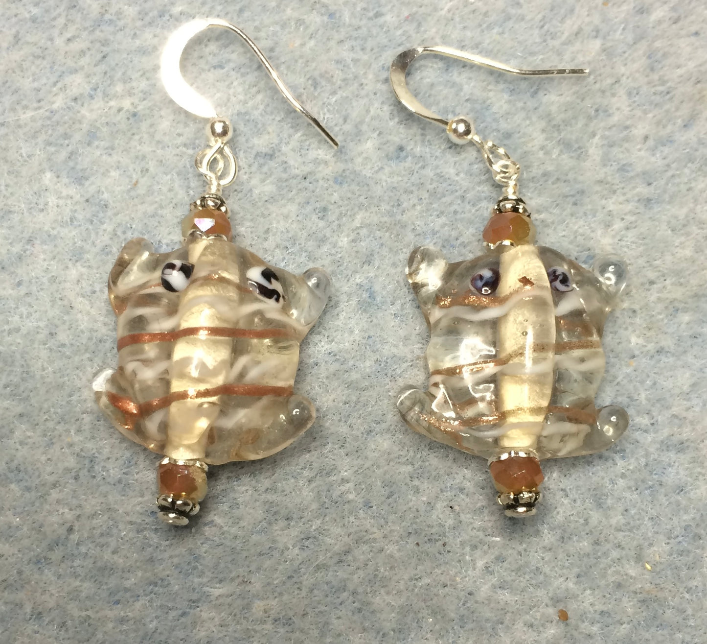 Clear and tan lamp work frog bead earrings adorned with tan Chinese crystal beads.