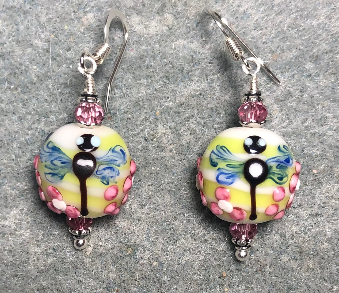 Pink, yellow, and blue lamp work dragonfly bead earrings adorned with hot pink Chinese crystal beads.