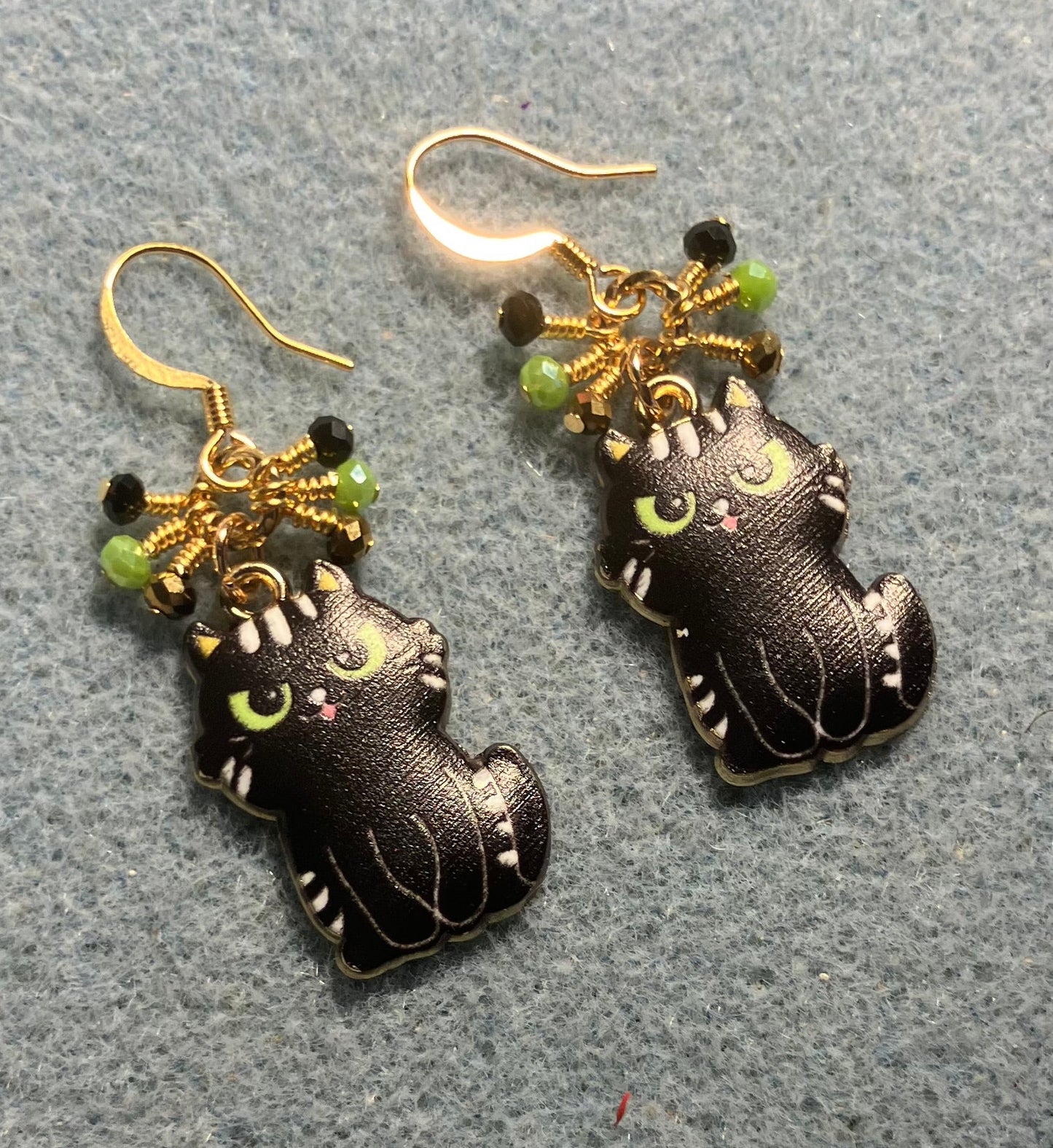 Black enamel cat charm earrings adorned with tiny dangling black, gold, and green Chinese crystal beads.