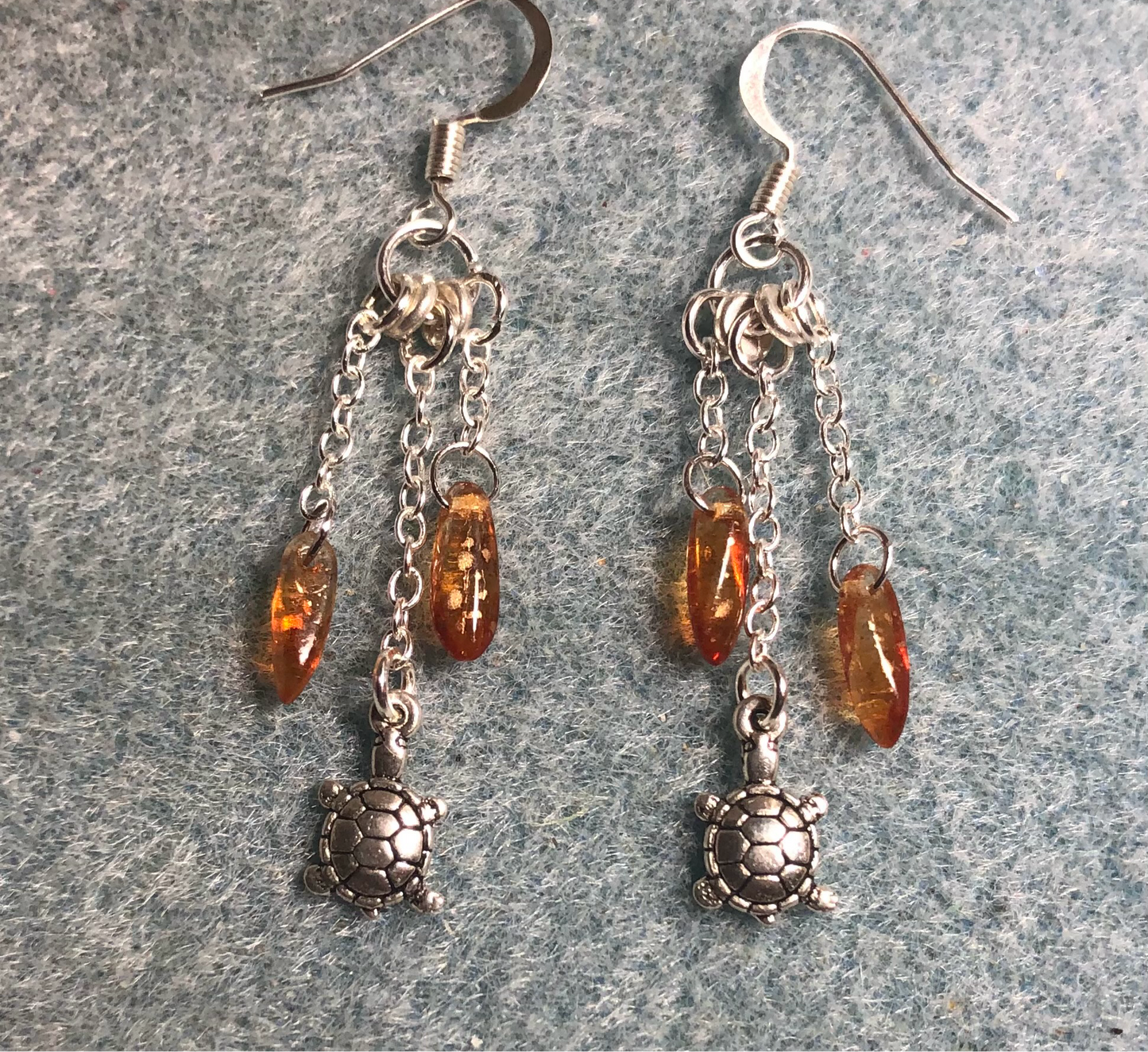 Small silver tortoise charm earrings attached to silver chain and adorned with small amber Czech glass dagger beads