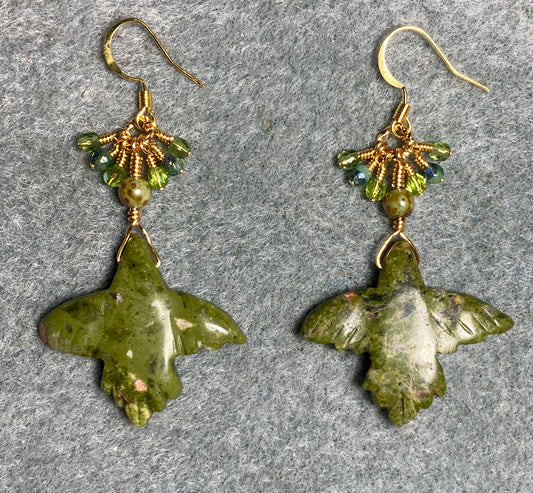 Large unakite gemstone flying eagle bead earrings adorned with tiny dangling green Czech glass beads.