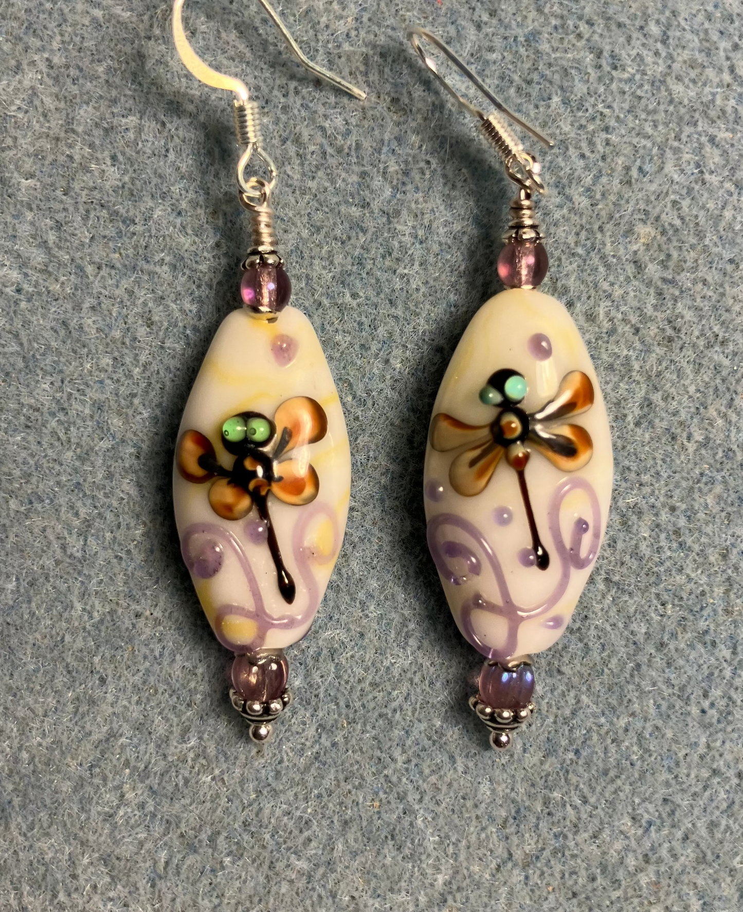 Off white, tan, and violet lamp work dragonfly bead earrings adorned with violet Czech glass beads.