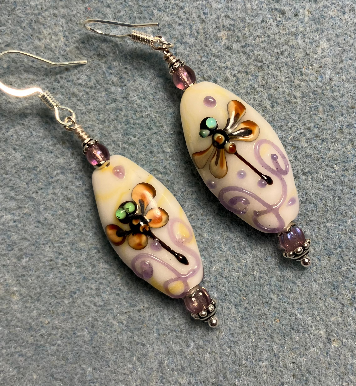 Off white, tan, and violet lamp work dragonfly bead earrings adorned with violet Czech glass beads.